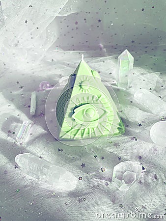 Esoteric candle clairvoyant pyramid surrounded by crystals. Stock Photo