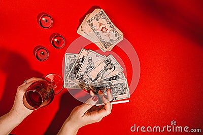 Tarot cards and female hands of fortune teller on red background Stock Photo