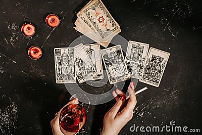 Tarot cards and female hands of fortune teller on black magic table Stock Photo