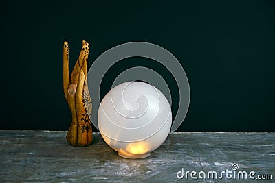 esoteric still life with a ball of predictions and wooden female hand on concrete table against black wall Stock Photo