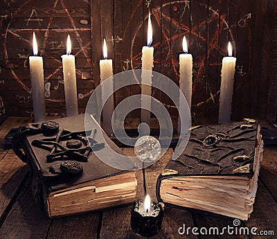 Esoteric still life with two black magic books and burning candles Stock Photo