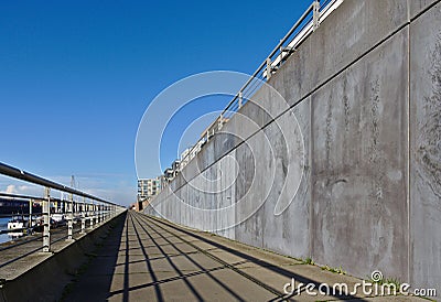 Esplanade along the Europa harbor in Bremen, Germany with metal railing, gray concrete wall, moored sailing yachts and a blue sky Stock Photo