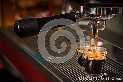 Espresso coffee pouring into glass shot Stock Photo