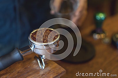 Espresso handle filled with ground coffee. Barista prepares espresso in his coffee shop Stock Photo