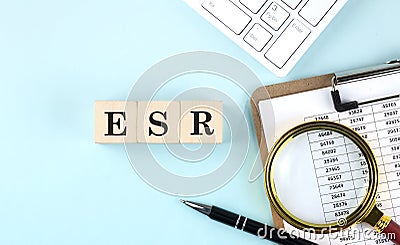 ESR Erythrocyte Sedimentation Rate word on wooden cubes on blue background with chart and keyboard Stock Photo