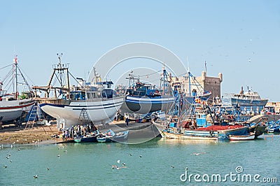 ESSAOUIRA/MOROCCO - MARCH 13, 2014: Big fishing ships and little boats in the city port Editorial Stock Photo