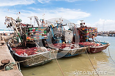 Essaouira, Morocco - March 16, 2018: Three fishing boats are moored in the port of Essaouira with the nets prepared on deck Editorial Stock Photo