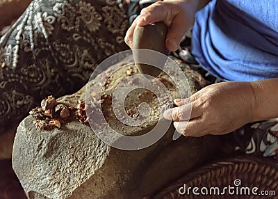 Making Argan Oil by Hand - smashing nuts open with a stone Stock Photo