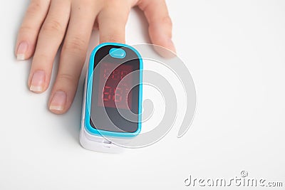An essential medical device for hypoxia. Female finger in a pulse oximeter Stock Photo