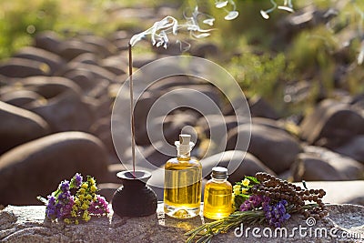 Essential Oils and Aromatic sticks for meditation on a rock Stock Photo