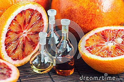 Essential oils in glass bottle with fresh, juicy, ripe, red orange. Beauty treatment. Spa concept. Selective focus. Stock Photo