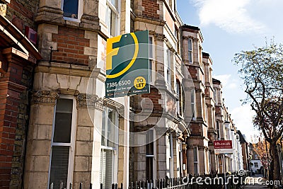 Estate agent signs outside a row of Victorian terraced houses Editorial Stock Photo