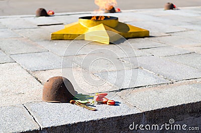 The eternal flame, in memory of the victims of 1941-1945, a bullet Pierced the helmet Stock Photo