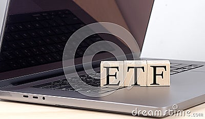 ETF word on wooden block on laptop, business concept Stock Photo