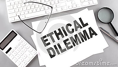 ETHICAL DILEMMA text on paper with keyboard, calculator on grey background Stock Photo