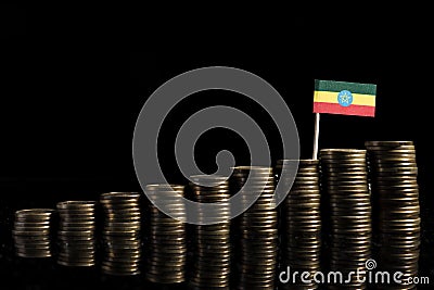 Ethiopian flag with lot of coins isolated on black Stock Photo