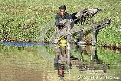 Ethiopian teen gets drinking water from water source Editorial Stock Photo