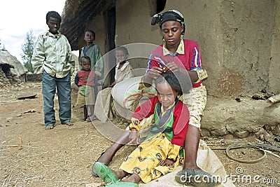 Ethiopian teenager braid her sisters hair Editorial Stock Photo