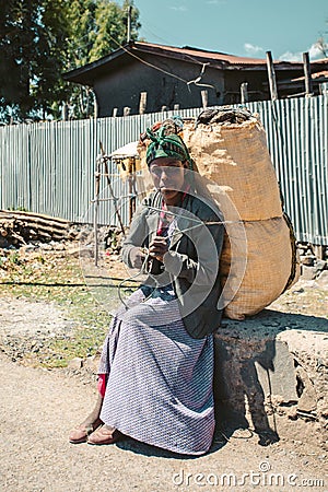 Ethiopian woman resting with sack of charcoal, Ethiopia Editorial Stock Photo