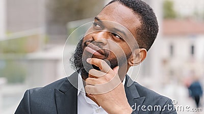 Ethnic bearded African American man entrepreneur pensive manager executive thoughtful worker employer ponder think about Stock Photo