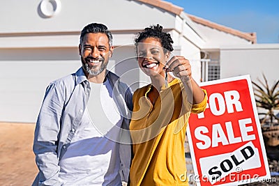 Ethnic couple holding new house keys Stock Photo