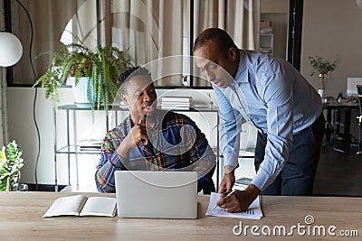 Ethnic male colleagues brainstorm over financial paperwork Stock Photo