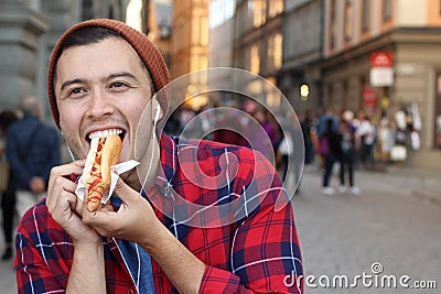 Ethnic male devouring a hot dog Stock Photo