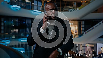 Ethnic middle-aged man entrepreneur answer phone call talking smartphone talk cellphone listen bad news frustrated loose Stock Photo