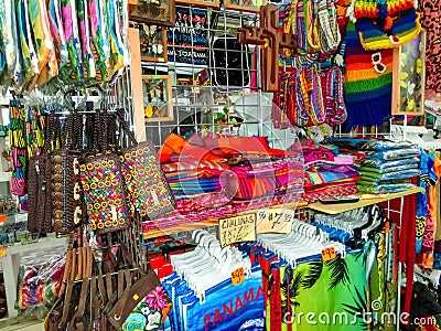 Ethnic souvenirs, baseball caps, bags with various pattern hanging in street market Stock Photo