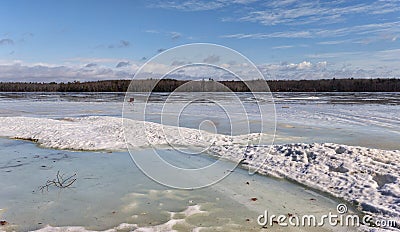 Etna Pond in Maine frozen with a chair sitting on the ice on a chilly winter day Stock Photo