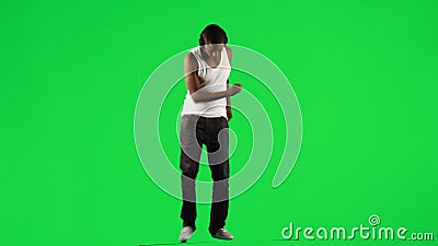Etnische jongen met een hoofdtelefoon op het dansen muziek tegen het groene scherm stock videobeelden Etnische jongen met een hoofdtelefoon op het dansen muziek tegen het groene scherm stock videobeelden