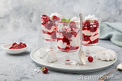 Eton mess, traditional english dessert, meringues, whipped cream, berry sauce and fresh raspberry in glass Stock Photo