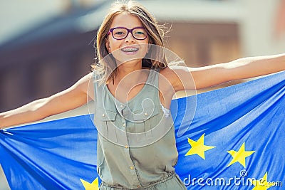 EU Flag. Cute happy girl with the flag of the European Union. Young teenage girl waving with the European Union flag in the city Stock Photo