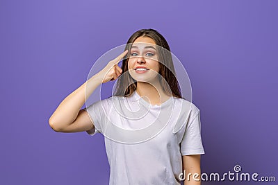 Eureka, finally got answer on question. Attractive pleasant young brunette woman holding index finger on temple and looking at Stock Photo