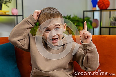 Thoughtful inspired child boy kid make Eureka gesture raises finger came up with creative plan Stock Photo