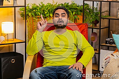 Thoughtful inspired Indian man make Eureka gesture raises finger came up creative plan at home Stock Photo