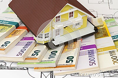 Euro banknotes laying under model home Stock Photo