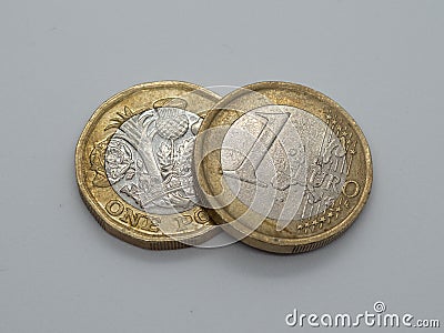 Euro coin resting on top of one pound coin Stock Photo