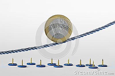 Euro coin on rope over push pins - Concept of upward trend of euro currency and euro currency risk Stock Photo