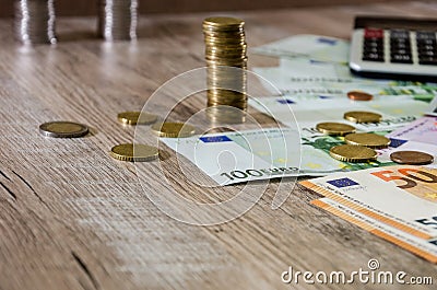 Euro, dollars, cents and calculator spread out on a wooden background Stock Photo
