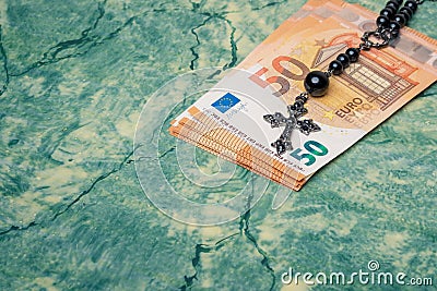 Euro money and black rosary Stock Photo