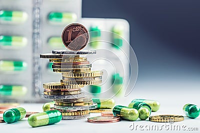 Euro money and medicaments. Euro coins and pills. Coins stacked on each other in different positions and freely pills around Stock Photo