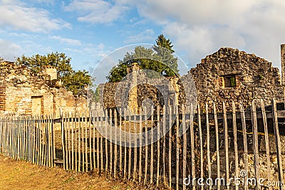 Ruined stone buildings behind a fence in the martyr village of Oradour-sur-Glane Editorial Stock Photo
