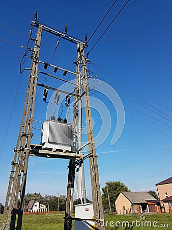 Europe. Poland country. Electrical technology. Tranformator of pawer in sunlight on a blue sky background. Electrical equipment of Stock Photo