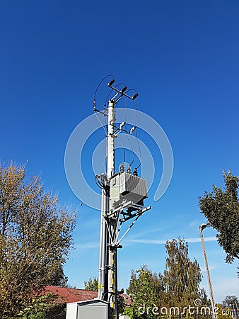 Europe. Poland country. Electrical technology. Tranformer of pawer in sunlight on a blue sky background. Electrical equipment of n Stock Photo