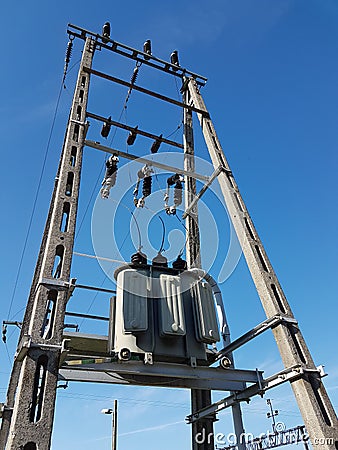 Europe. Poland country. Electrical technology. Tranformer of pawer in sunlight on a blue sky background. Electrical equipment of n Stock Photo