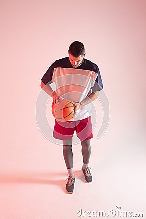 European basketball player holding ball in studio Stock Photo