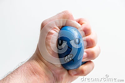 European male hand squeezing an anti-stress ball with the strong fingers shows stress and anger, anxiety and frustration Stock Photo