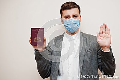 European man in formal wear and face mask, show Netherlands passport with stop sign hand. Coronavirus lockdown in Europe country Stock Photo