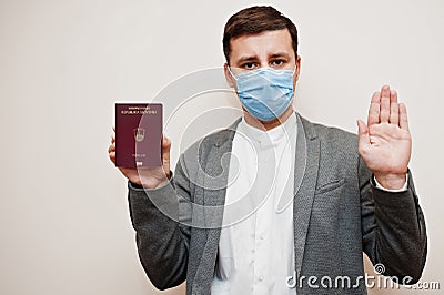 European man in formal wear and face mask, show Slovenia passport with stop sign hand. Coronavirus lockdown in Europe country Stock Photo